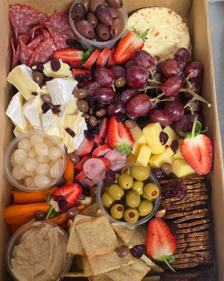 A catering grazing box with meats, cheese, fruit and crackers